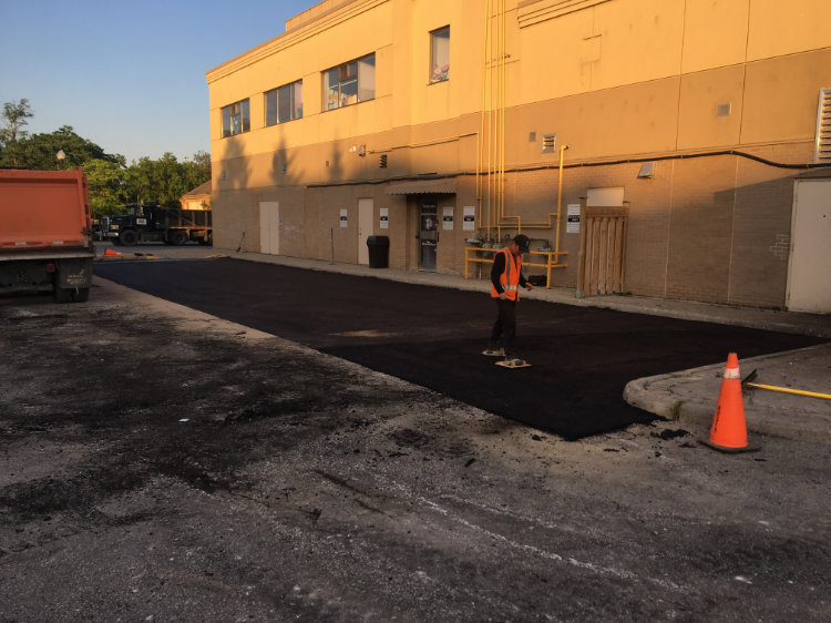 smoothing out the asphalt on a commercial lot
