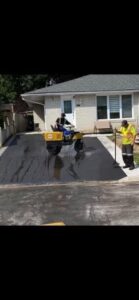 Rolling out the finished paved driveway in Arthur